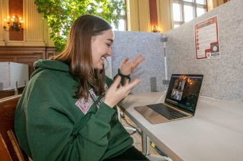 A student uses a laptop to participate in a Zoom call.